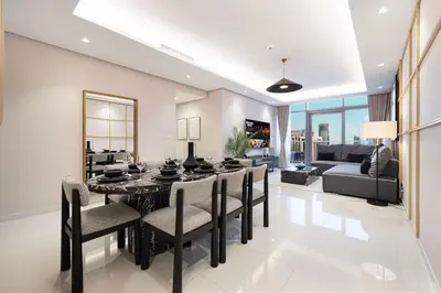 a dining room with a black table and chairs at Premium 3BR Paramount Hotel Midtown Business Bay in Dubai