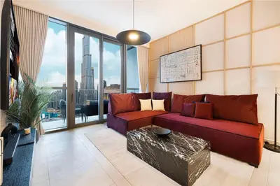 a living room with a red couch and large windows at Spacious 4BR for 12 Burj View PS5 Dubai Mall in Dubai