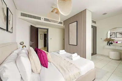 a living room with a white couch with pillows at Silkhaus 2BDR Heart of DIFC in Sky Gardens in Dubai