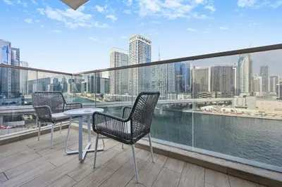 two chairs and a table on a balcony with a view of the city at Bloomfields Spacious 2BR at Canal Bay in Dubai