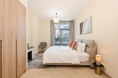 a bedroom with a bed and a desk and a window at Bloomfields Spacious 2BR at Canal Bay in Dubai