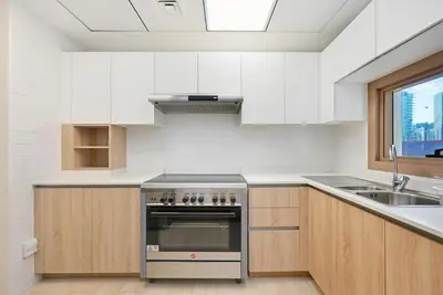 a kitchen with white cabinets and a stainless steel oven at Bloomfields Spacious 2BR at Canal Bay in Dubai