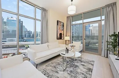 a living room with white furniture and large windows at Bloomfields Spacious 2BR at Canal Bay in Dubai