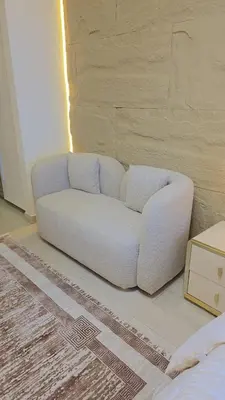 a white couch sitting in the corner of a room at Luxury Studio with Burj Khalifa View in Dubai