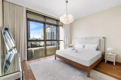 a bedroom with a white bed and a large window at Upscale 4BR Loft Duplex plus Maid in Creekside, Creek Harbour in Dubai