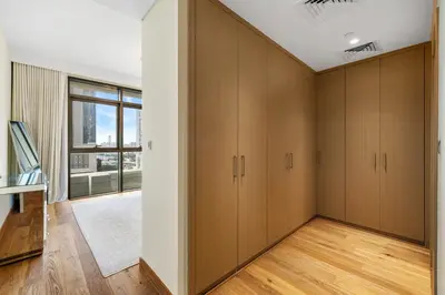 an empty room with wooden cabinets and a window at Upscale 4BR Loft Duplex plus Maid in Creekside, Creek Harbour in Dubai