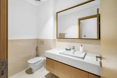 a bathroom with a sink and a toilet and a mirror at Upscale 4BR Loft Duplex plus Maid in Creekside, Creek Harbour in Dubai