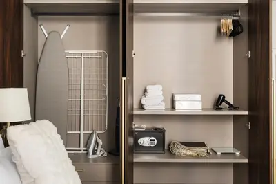 a bedroom with a closet with a bed and a shelf at Brand New 1BR Near Metro at Avenue Residence in Dubai