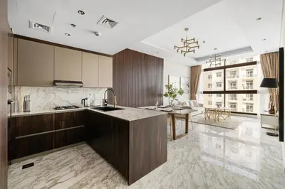a kitchen with wooden cabinets and a counter top at Brand New 1BR Near Metro at Avenue Residence in Dubai