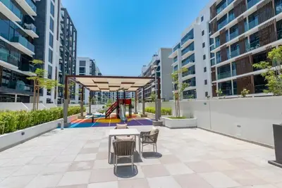 a patio with a table and chairs and a playground at Luxury Studio With Burj Khalifa Views in Dubai