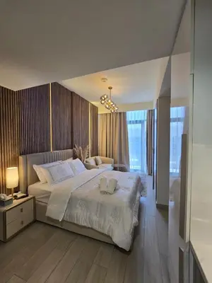 a bedroom with a large bed with two towels on it at Luxury Studio With Burj Khalifa Views in Dubai