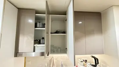 a kitchen with white cabinets and a sink at Luxury Studio with Pool Views in Dubai