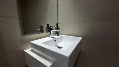a white sink in a bathroom with a mirror at Luxury Studio with Pool Views in Dubai