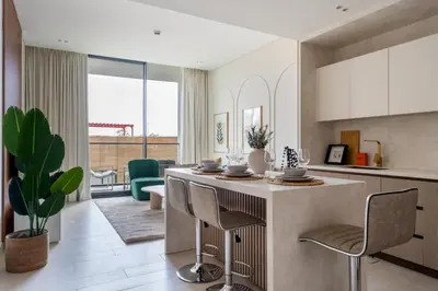 a kitchen with a counter and chairs in a room at GuestReady - Spacious 1 bedroom apartment in Dubai