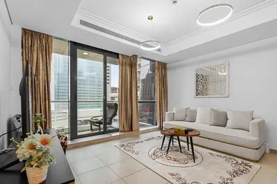 a living room with a couch and a table at Modern 2BR Apartment - City Views - Goldcrest Views 2 in Dubai