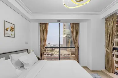 a bedroom with a bed and a large window at Modern 2BR Apartment - City Views - Goldcrest Views 2 in Dubai