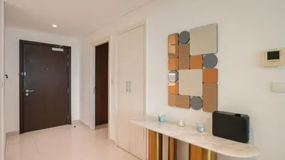 a room with a table and a tv on a wall at Deluxe Pool View apartment in BLVD Crescent Downtown Dubai by Norbu Holiday Homes in Dubai