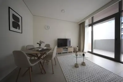a living room with a table and chairs and a television at Elegant 1BR with Balcony in West Five Business Bay in Dubai