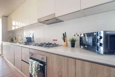 a kitchen with a stove and a microwave at Frank Porter - Liv Residence in Dubai
