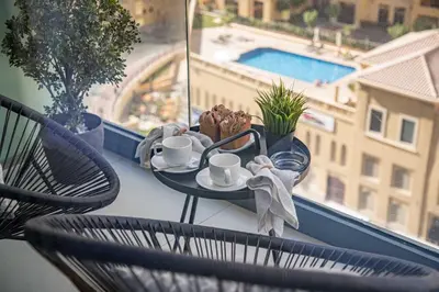 a table with a tray of food and coffee cups on a balcony at Frank Porter - Liv Residence in Dubai