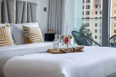 a white bed with a tray with flowers on it at Frank Porter - Liv Residence in Dubai
