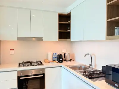 a kitchen with white cabinets and a sink at Luxury Burj Khalifa View Downtown Residence at Burj Vista Apartment in Dubai