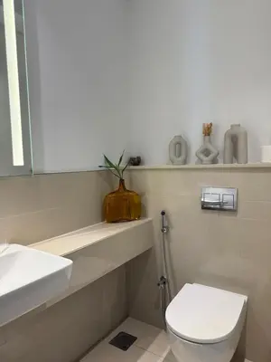 a white bathroom with a toilet and a sink at Bluebell reidence jvc in Dubai