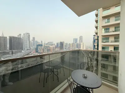 a balcony with tables and chairs and a view of a city at Luxury Apartments in Burj Vista Dubai With Burj Khalifa View Near Dubai Mall in Dubai