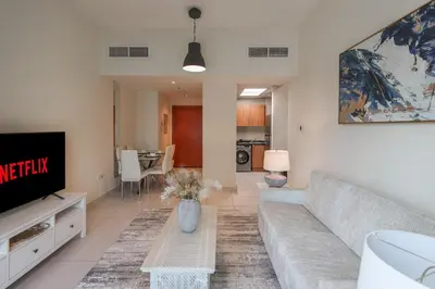 a living room with a couch and a tv at Bright 2BR in Dubai Marina - Close to beach in Dubai