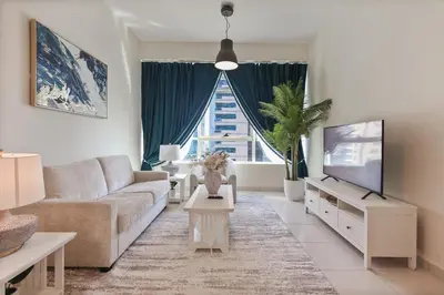 a living room with a couch and a tv at Bright 2BR in Dubai Marina - Close to beach in Dubai