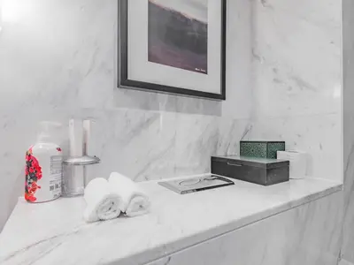 a white bathroom counter with towels and a picture at Direct Dubai Mall Access-Emaar Residences-1BR Like Home in Dubai