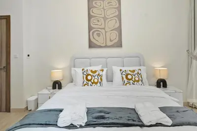a bedroom with a large white bed with two lamps at Luxury Brand New 2 BR Apartment Burj & Canal View Business Bay Dubai in Dubai
