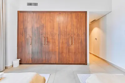 a large wooden door in a room with a bed at Burj Vista Luxury Apartments with Burj Khalifa View in Dubai
