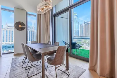 a dining room with a table and chairs and a large window at Burj Vista Luxury Apartments with Burj Khalifa View in Dubai