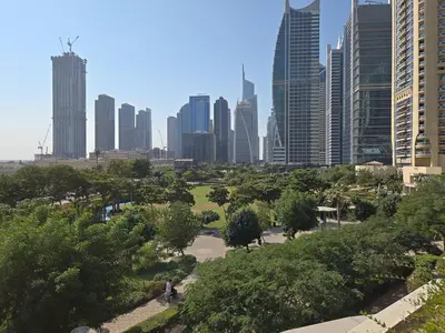 a park in a city with tall buildings at JLT Cozy and Modern 1BR Pool and Gym Walk to Metro in Dubai