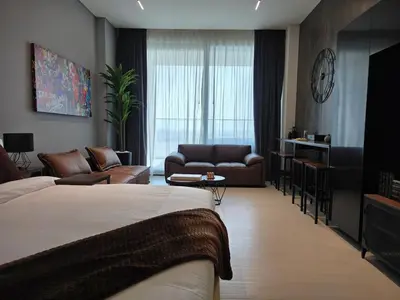 a hotel room with a bed and a living room at Trillionaire Bayhouse Chic Studio - Jacuzzi with views, Pool and Gym in Dubai