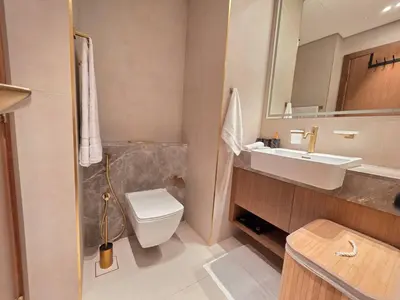 a bathroom with a sink and a toilet and a mirror at Trillionaire Bayhouse Chic Studio - Jacuzzi with views, Pool and Gym in Dubai