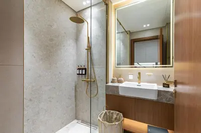 a bathroom with a shower and a sink and a mirror at The Trillionaire Bayhouse - Private Jacuzzi, Sauna, pool and gym in Dubai