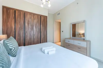 a bedroom with a large white bed and a television at Vacationer l Elegant 1 Bed l Next to Metro l Near Mall in Dubai