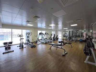 a gym with several treadmills and machines in a room at Business Bay 1 BR on Canal 7 min to Dubai Mall in Dubai