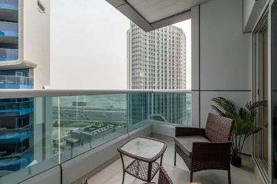 a balcony with two chairs and a table on a building at Business Bay 1 BR on Canal 7 min to Dubai Mall in Dubai
