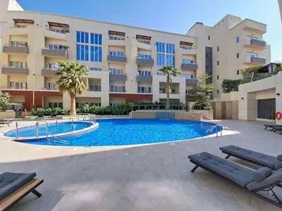 a swimming pool in front of a building at Vacationer l Modern Aesthetic 1 Bed l JVC l near Circle Mall in Dubai