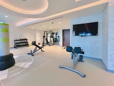 a gym with treadmills and exercise equipment in a room at Waves - Beachfront Bliss - Marina Vista 1BR Escape in Dubai