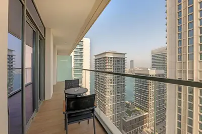a balcony with a table and a view of a city at Waves - Beachfront Bliss - Marina Vista 1BR Escape in Dubai