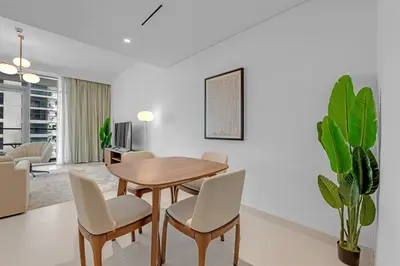 a dining room with a wooden table and chairs at Waves - Beachfront Bliss - Marina Vista 1BR Escape in Dubai