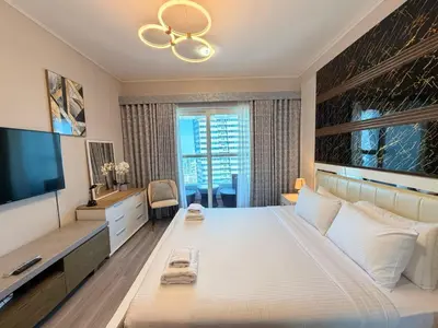 a bedroom with a large bed and a television at Panoramic Fireworks Views with Palm Jumeirah Bluewaters and Ain dubai View in Dubai