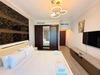 a hotel room with a bed and a flat screen tv at Panoramic Fireworks Views with Palm Jumeirah Bluewaters and Ain dubai View in Dubai