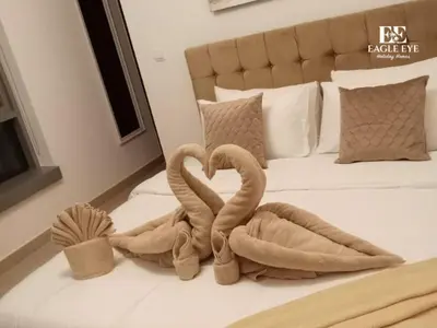 two towel swans making a heart on a bed at 2BR Downtown Dubai - Near Burj Khalifa - Private Podium Seating - Sleeps 4 in Dubai