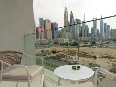 a balcony with a table and chairs and a view of the city at Stylish new apartment with Burj and Downtown views in Dubai