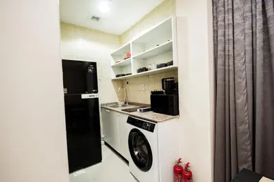 a small kitchen with a washer and dryer at Newly furnished Studio at city tower building in barsha 1 in Dubai